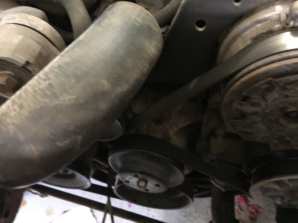 Serpentine belt system and pulleys in the engine bay of a 1987 Ford Bronco.