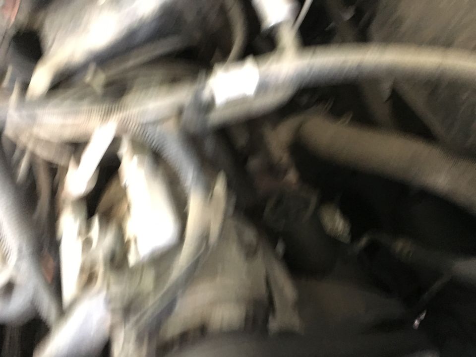 Blurry engine bay of a 1987 Ford Bronco with hoses and wires.