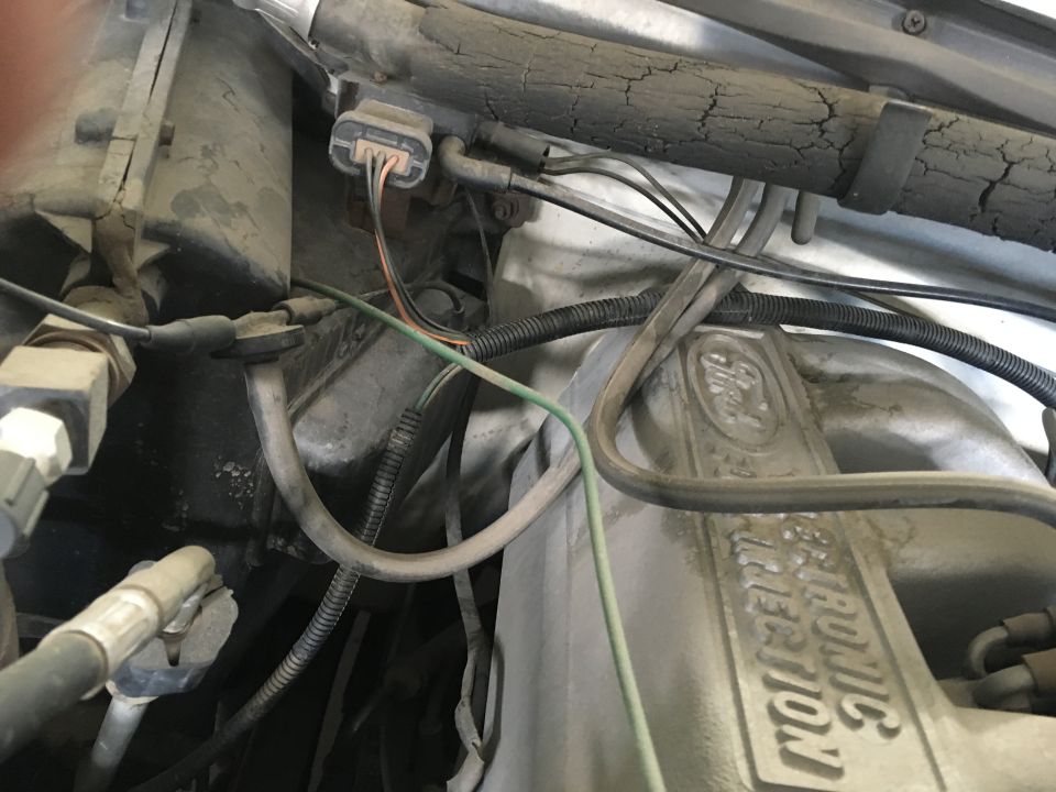 Close-up of Ford Bronco engine bay with hoses, wires, and "Electronic Fuel Injection" text.