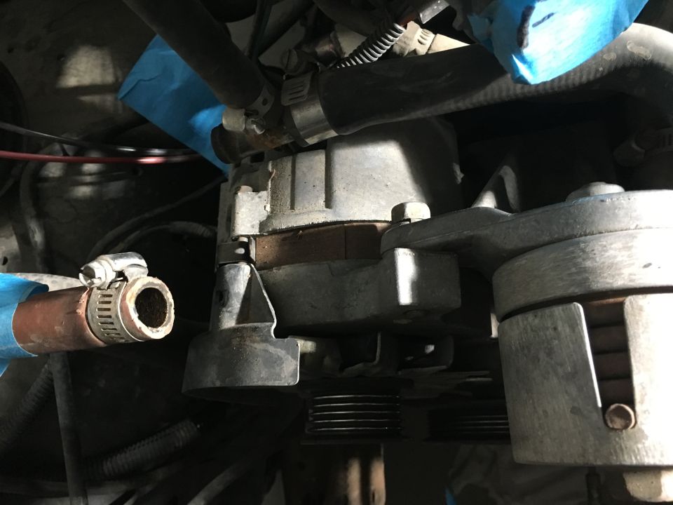 1987 Ford Bronco engine bay close-up: belt tensioner, hoses, clamps, blue tape