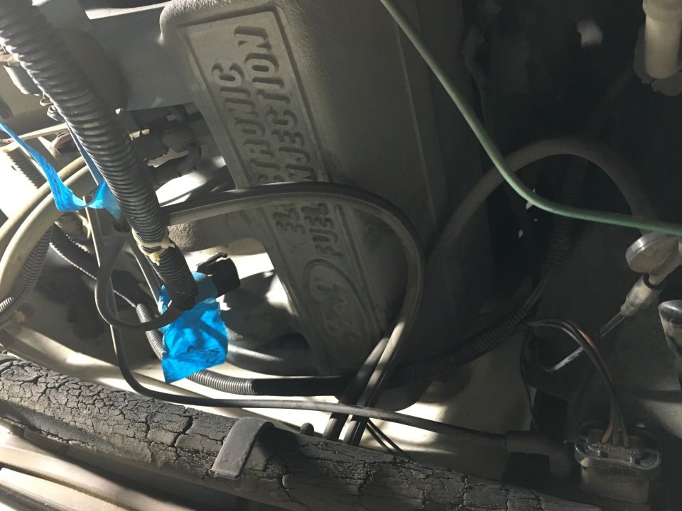 Engine bay with electronic fuel injection cover, wires, and hoses.