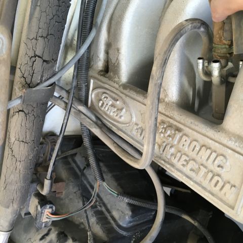 1987 Ford Bronco - Close-up view of a Ford electronic fuel injection intake manifold with visible "Ford" branding. Wires and hoses are connected to the engine…
