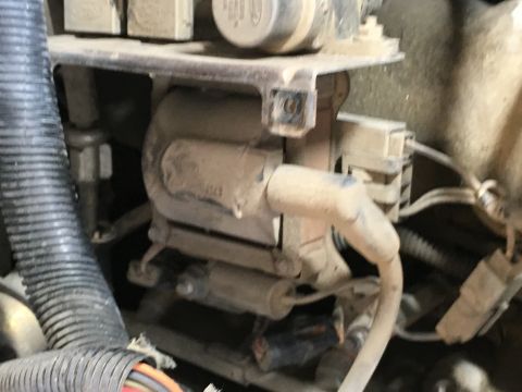 1987 Ford Bronco - A close-up view of a dusty engine component, likely a coil pack, with various wires and connectors visible in the engine bay of a 1987 Ford…