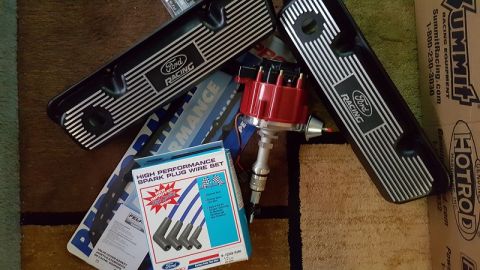 1978 Ford Bronco - A collection of Ford performance parts including two black Ford Racing valve covers, a red distributor, and a box of Ford High Performance…