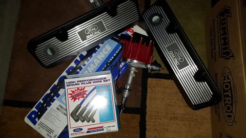 1978 Ford Bronco - A collection of Ford Racing performance parts, including valve covers, a spark plug wire set, and a distributor, are laid out on a carpeted…