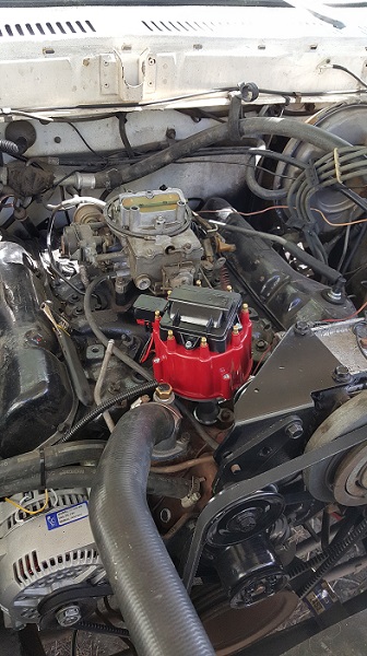 1978 Ford Bronco - The image shows a close-up view of a V8 engine bay, likely from a 1978 Ford Bronco, featuring a carburetor and a red distributor cap. The e…
