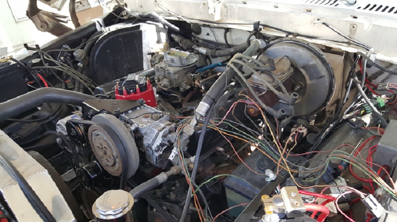 1978 Ford Bronco engine bay with V8 engine, carburetor, and wiring.