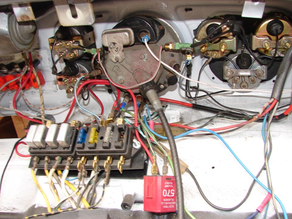 Close-up of Volkswagen Beetle dashboard wiring harness and fuse box with relays.