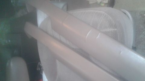1996 Ford Bronco - Two light tan interior trim pieces are laid across a light tan vehicle seat. The trim pieces appear to be for the door panels and have some…