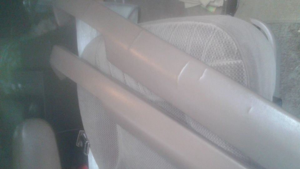 Two tan interior trim pieces on a tan vehicle seat.