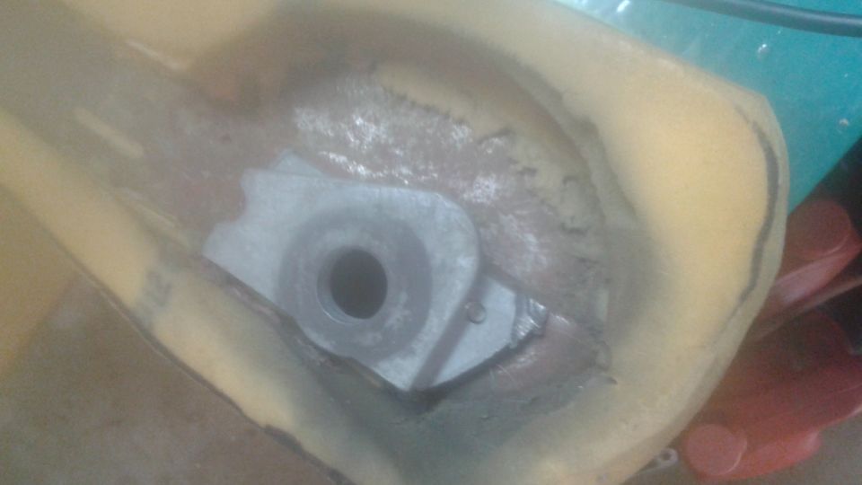 Metal bracket with hole embedded in yellow foam.