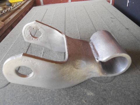 1972 Ford Bronco - A metal bracket with two holes and a cylindrical end is shown in a close-up shot. The bracket appears to be a vehicle part, possibly for a…