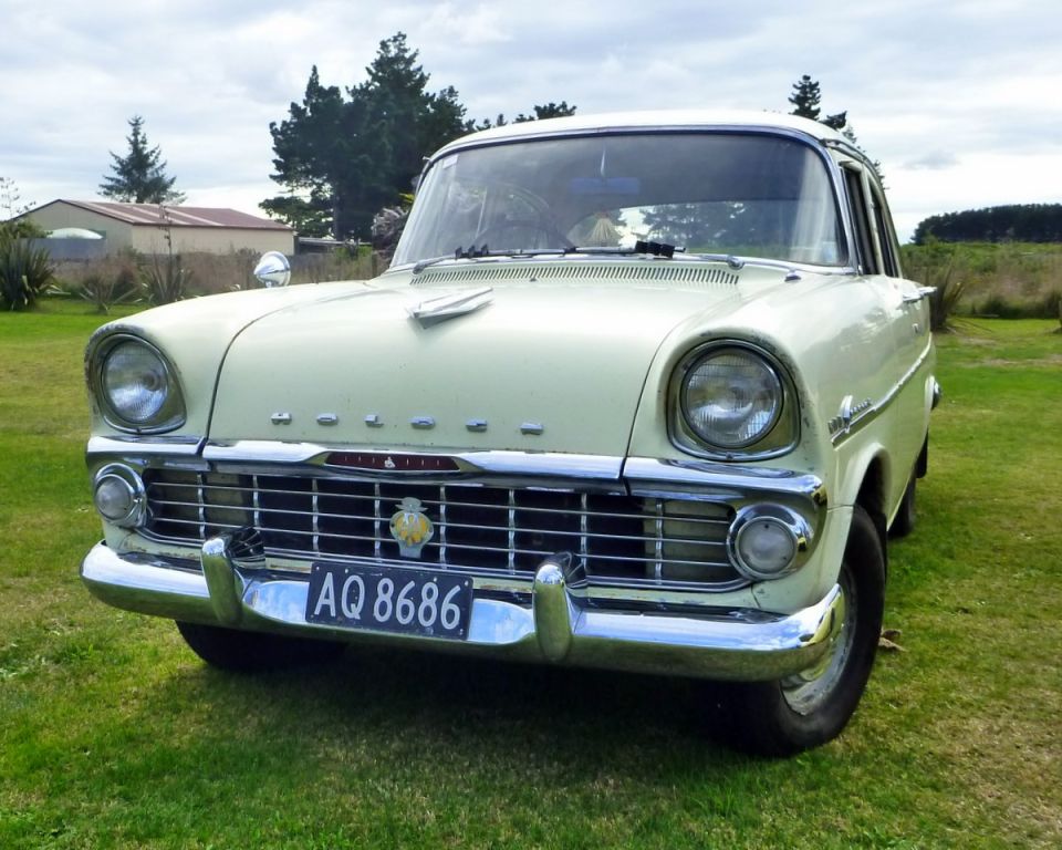 Pale yellow classic sedan with chrome grille and license plate AQ 8686