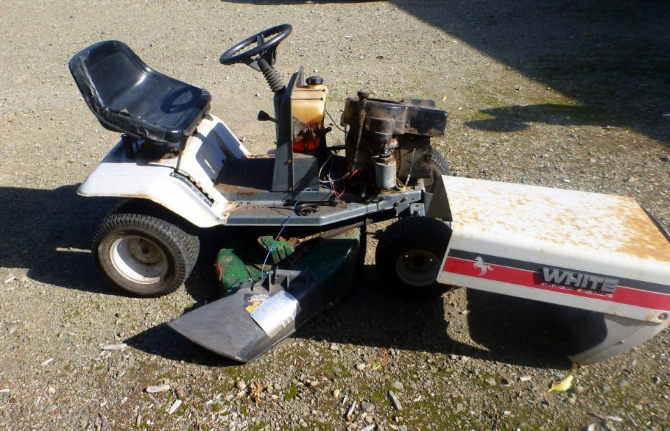 White riding lawn mower with red stripe and 'WHITE' text on the hood