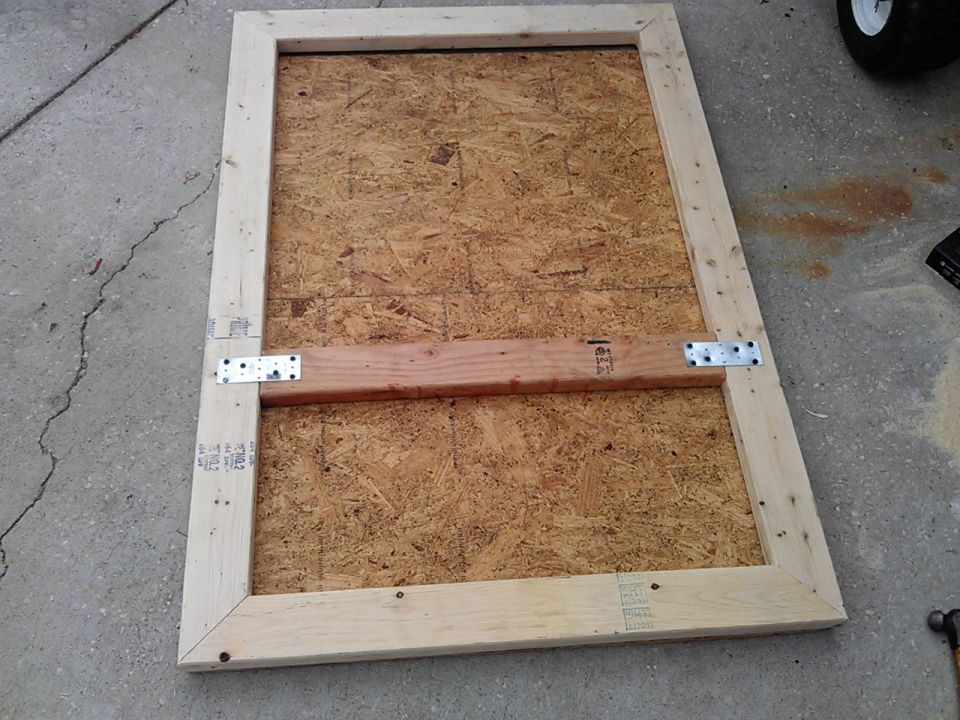 Homemade wooden frame with OSB backing, attached with metal brackets