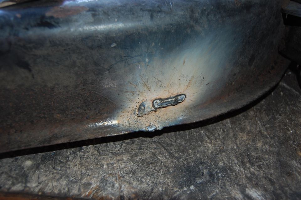 Close-up of a rusty metal part with visible welds.