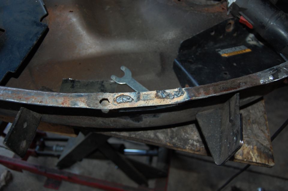 Welding a metal frame with a wrench and power tool visible.