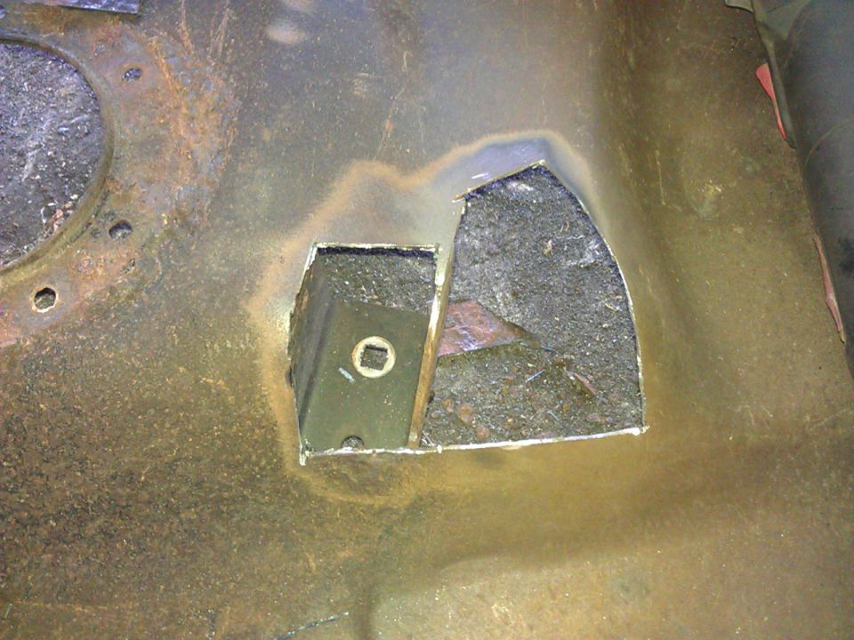 Rusted metal surface with a cut-out revealing a dark component.