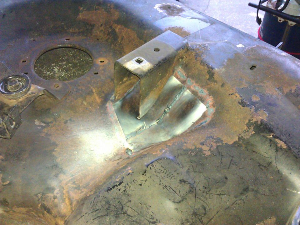 Rusty lawnmower deck with a welded patch and bracket