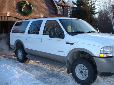 2003 Ford Excursion - A white Ford Excursion is parked in the snow outside a brick house with a wreath on the garage door.