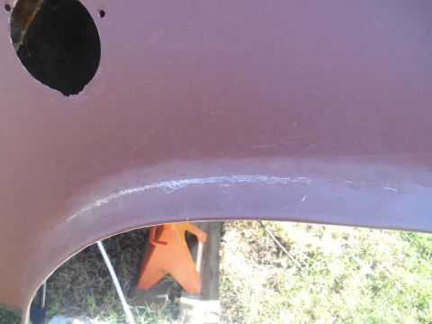 1972 Ford Bronco - A close-up view of the underside of a vehicle's body panel, showing a seam with what appears to be filler or repair material. An orange jac…