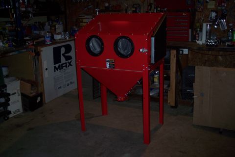 1990 Ford Bronco - A red sandblasting cabinet is shown in a workshop setting. The cabinet has two circular windows on the front and stands on four red legs.