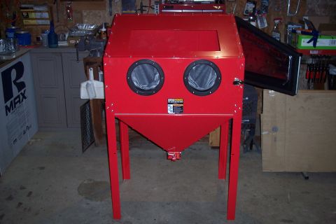 1990 Ford Bronco - A red sandblasting cabinet with two glove ports and a clear viewing window is shown in a workshop setting.