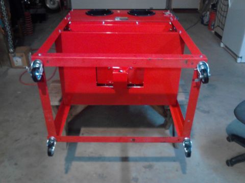 1990 Ford Bronco - A bright red sandblaster cabinet with four caster wheels is shown from a front-facing angle. The cabinet has two circular openings on its t…