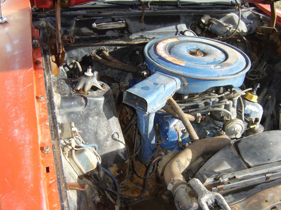 Engine bay of a vintage Ford Ranchero with blue air cleaner.