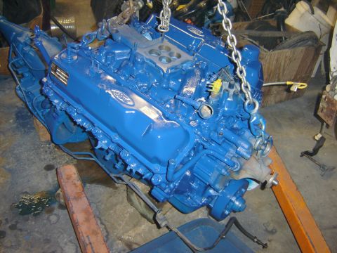 1971 Ford Ranchero - A bright blue Ford V8 engine assembly, likely a 351 Windsor or Cleveland, is suspended by chains from an engine hoist. The engine features…