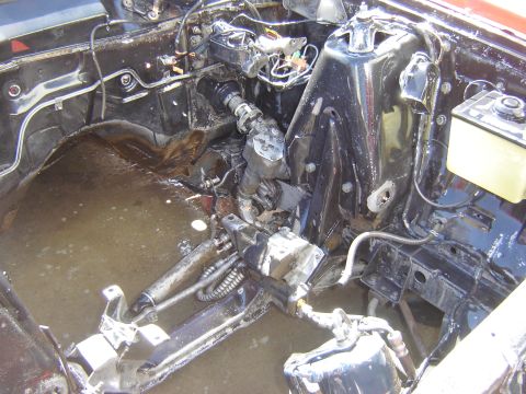 1971 Ford Ranchero - The engine bay of a classic vehicle is shown, filled with water and debris. Visible components include the master cylinder, brake booster,…