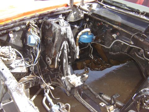 1971 Ford Ranchero - The engine bay of a classic vehicle is shown, with the engine removed. The firewall and inner fenders are coated in black paint, with some…
