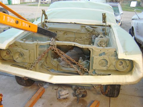 1971 Ford Ranchero - A light green car, possibly a 1971 Ford Ranchero, is covered in protective sheeting with its hood open, revealing the engine bay being supp…