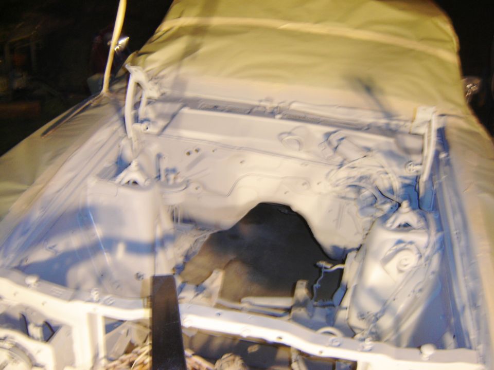 White primer painted engine bay under a protective tarp.