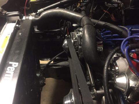 1982 Ford Bronco - A close-up view of the engine bay of a classic vehicle, focusing on the radiator, hoses, and serpentine belt system. The radiator has the w…