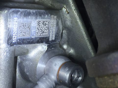 1994 Ford Bronco - A close-up view shows a metal plate with serial numbers and QR codes affixed to a vehicle part. The visible text includes "15252061218", "E…