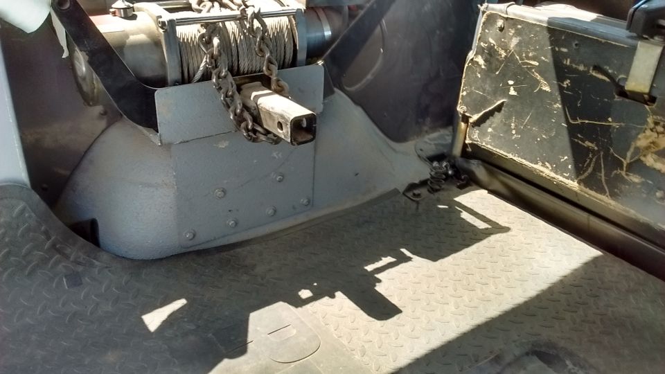 Black rubber cargo mat with a textured surface, partially visible tire and vehicle body