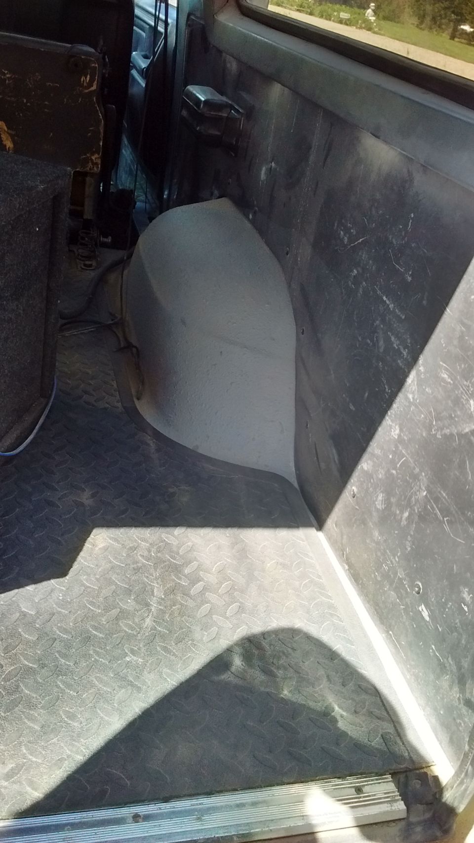 Diamond plate flooring and gray plastic interior panels in a vehicle's cargo area