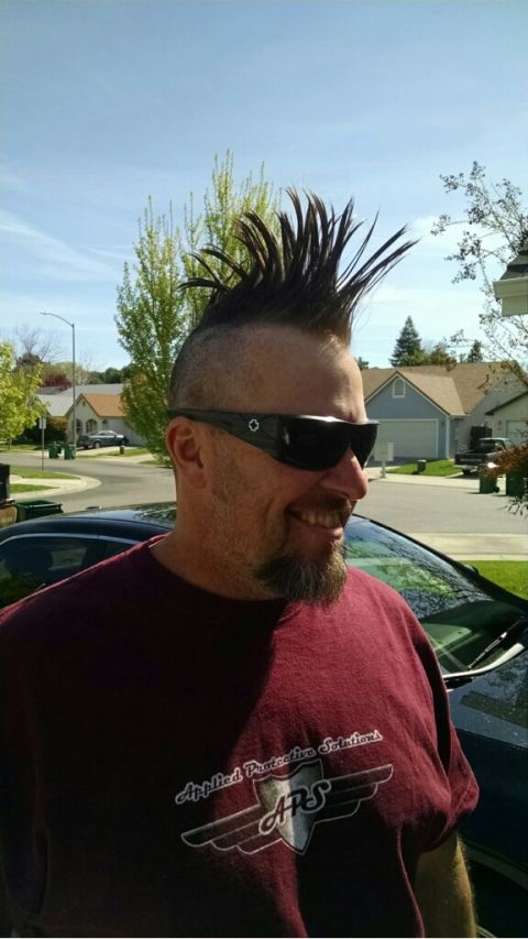 1985 Jeep CJ7 - A man with a mohawk and sunglasses smiles while wearing a maroon t-shirt with a logo on it. He is standing outdoors with a suburban neighbo…