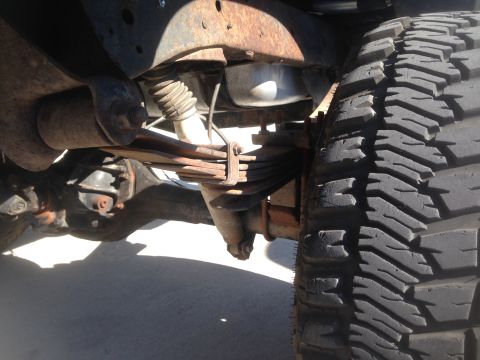 1979 Ford Bronco - A close-up view of the undercarriage of a vintage Ford Bronco, focusing on the suspension system including leaf springs, a shock absorber,…