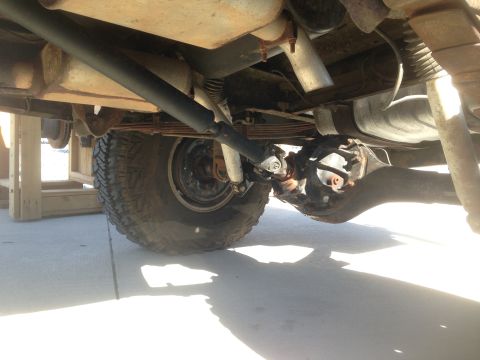 1979 Ford Bronco - The underside of a vehicle shows the rear axle assembly, leaf springs, exhaust system, and a portion of a large tire. The vehicle appears t…