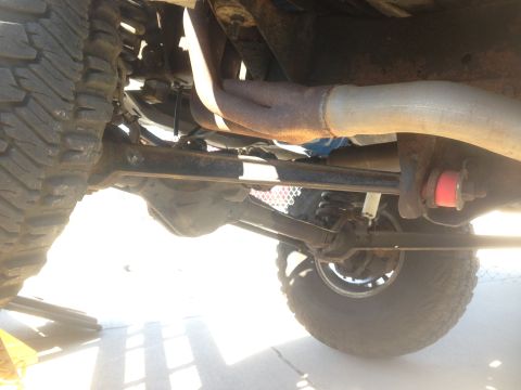 1979 Ford Bronco - The underside of a vehicle, likely a 1979 Ford Bronco, shows the suspension and exhaust system. The image focuses on the rusty exhaust pipe…
