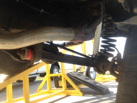 1979 Ford Bronco - The underside of a vehicle is shown, focusing on the rear suspension components including a coil spring, shock absorber, and exhaust pipe.…