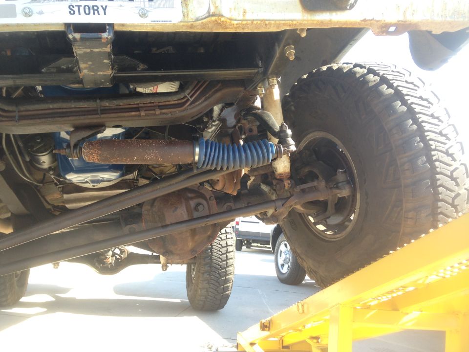 Underside of a 4x4 vehicle with large tires and suspension components.