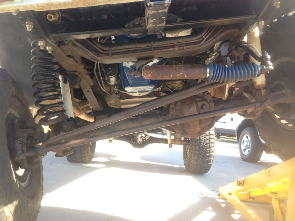 Underside of a lifted 4x4 vehicle showing suspension and steering components.