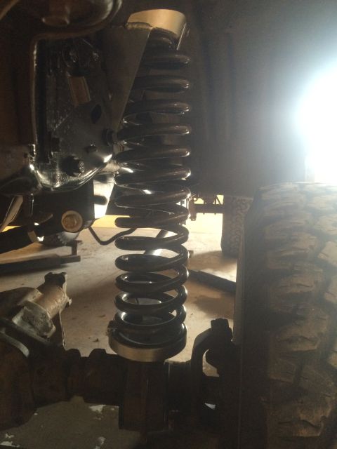 1996 Ford Bronco - A close-up view of the suspension system of a 1996 Ford Bronco, focusing on the coil spring and shock absorber assembly. The vehicle appear…