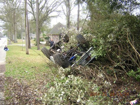 1984 Chevrolet Blazer - An off-road vehicle has flipped onto its side and is partially obscured by dense foliage.