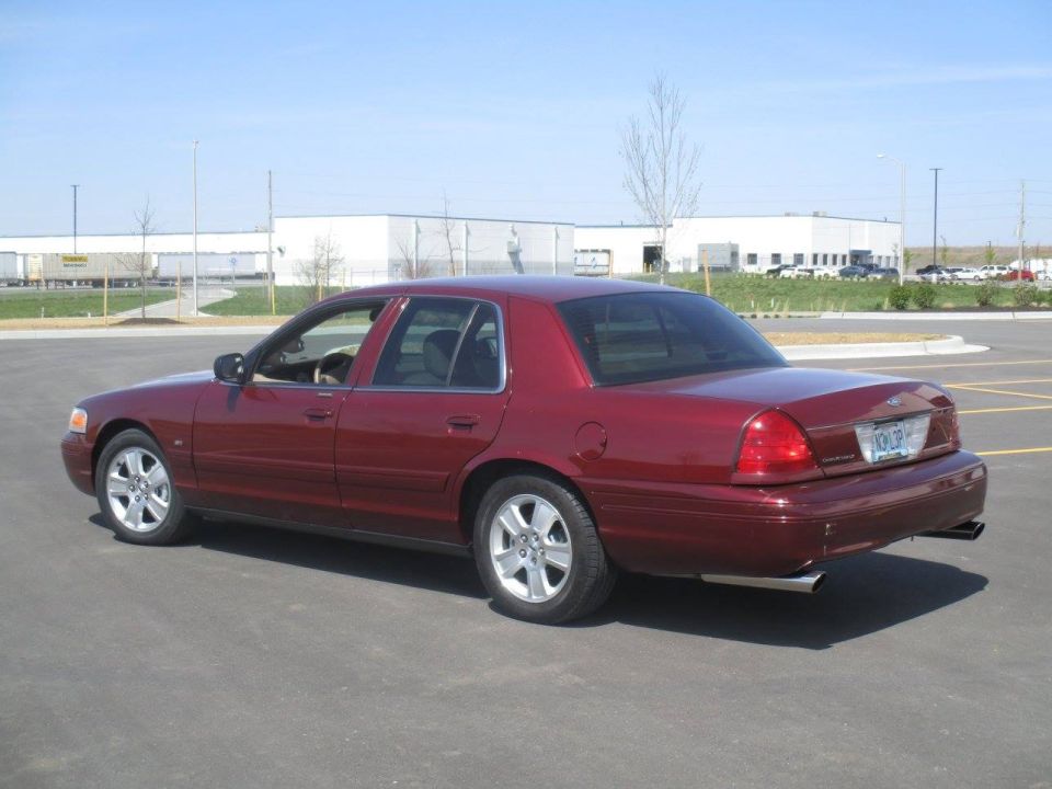 Dark red 2004 Ford Crown Victoria sedan, rear passenger side view.