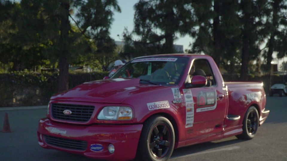 Red Ford F-150 Lightning pickup truck with racing decals.