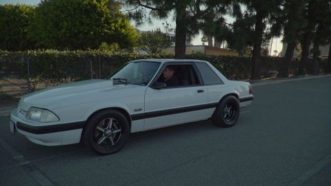 1993 Ford Taurus - A white sedan is captured from the side, its body style suggesting it could be from the late 1980s or early 1990s.